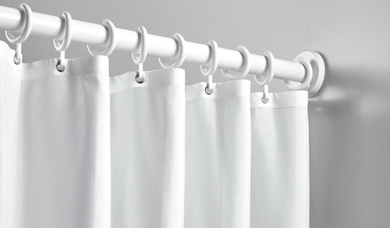 Shower curtain with rings attached to a shower rail