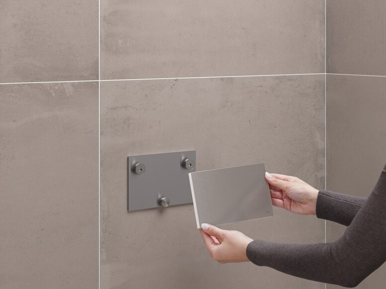 HEWI mounting plate in the installation Cover cap in the colour taupe, which is attached to a permanently installed mounting plate